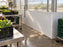 White greenhouse wall panels behind a wash sink and hose reel station
