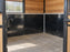 HDPE stall wall liner installed in a cedar-paneled horse stall with a barred window view
