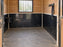 HDPE horse stall wall liner with a water bucket and lead rope hooks mounted above
