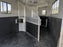 Black wall liner in a horse trailer stall with a mounted feed bucket
