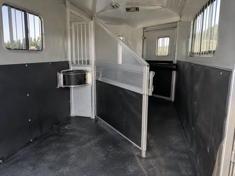 Black wall liner in a horse trailer stall with a mounted feed bucket
