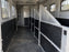 Horse trailer wall liner installed along a multi-stall hallway with a tack storage area
