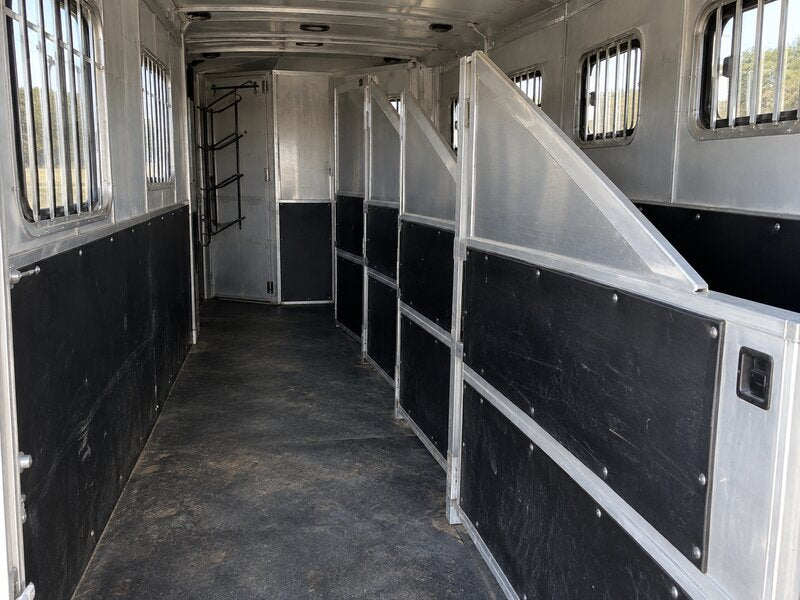 Horse trailer wall liner installed along a multi-stall hallway with a tack storage area
