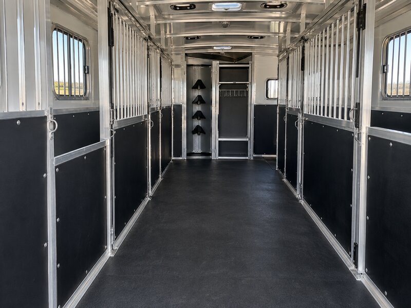 Horse trailer wall liner lining a stall hallway leading to a tack storage area
