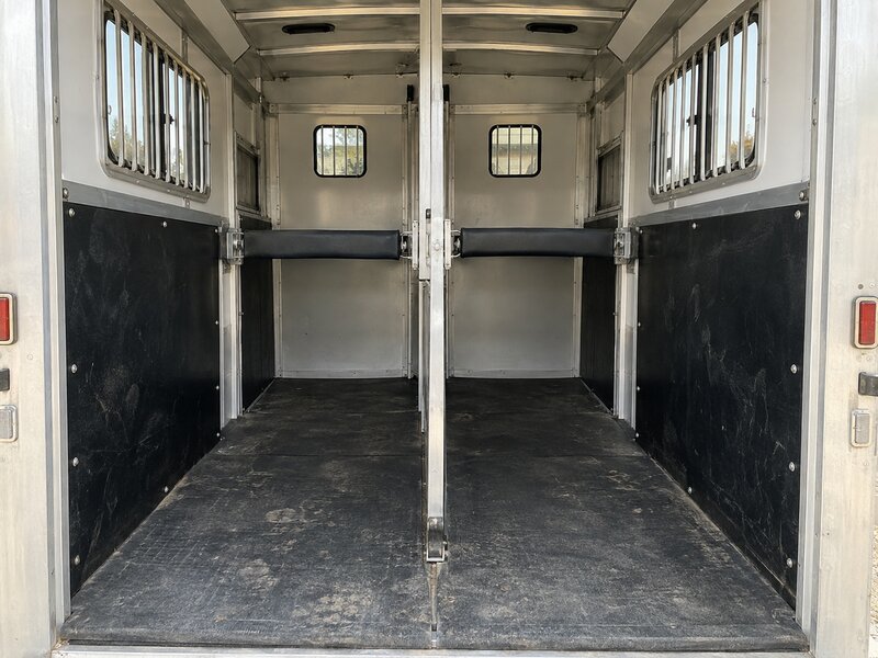Black HDPE horse trailer wall liner installed in a two-horse trailer with a center divider
