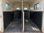 Black wall liner installed in a vintage horse trailer interior with barred windows
